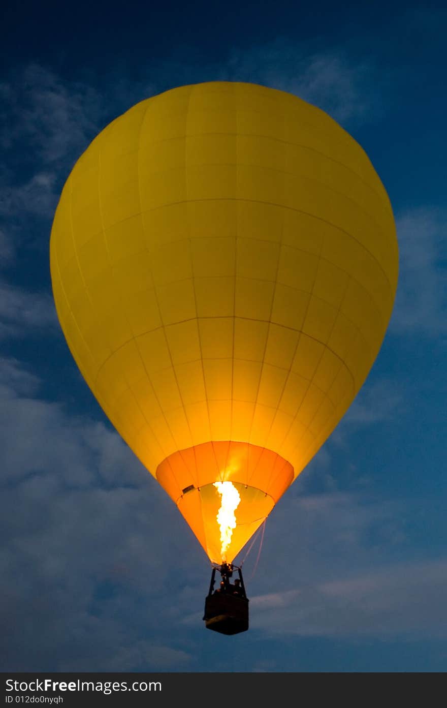 Yellow balloon flying at night, dark blue sky,