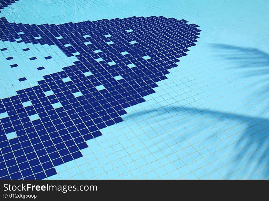 A cool blue tropical swimming pool with a suggestive shadow of a palm tree. A cool blue tropical swimming pool with a suggestive shadow of a palm tree