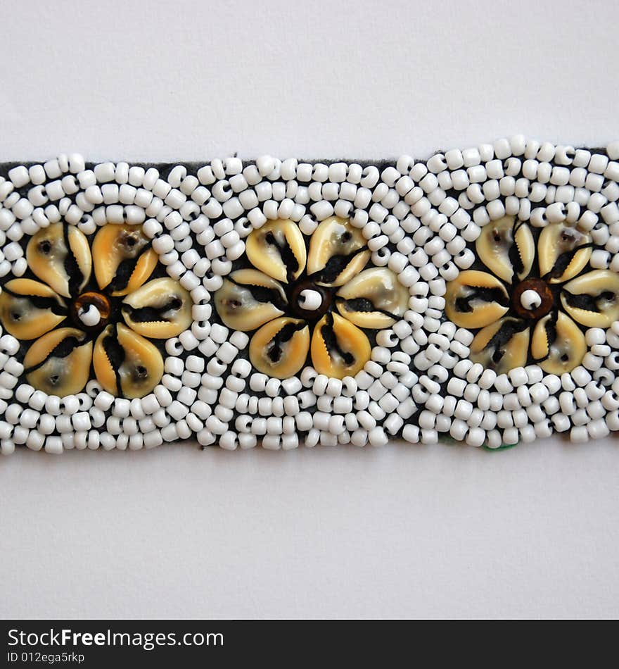 A detail of a belt with shells and pearls