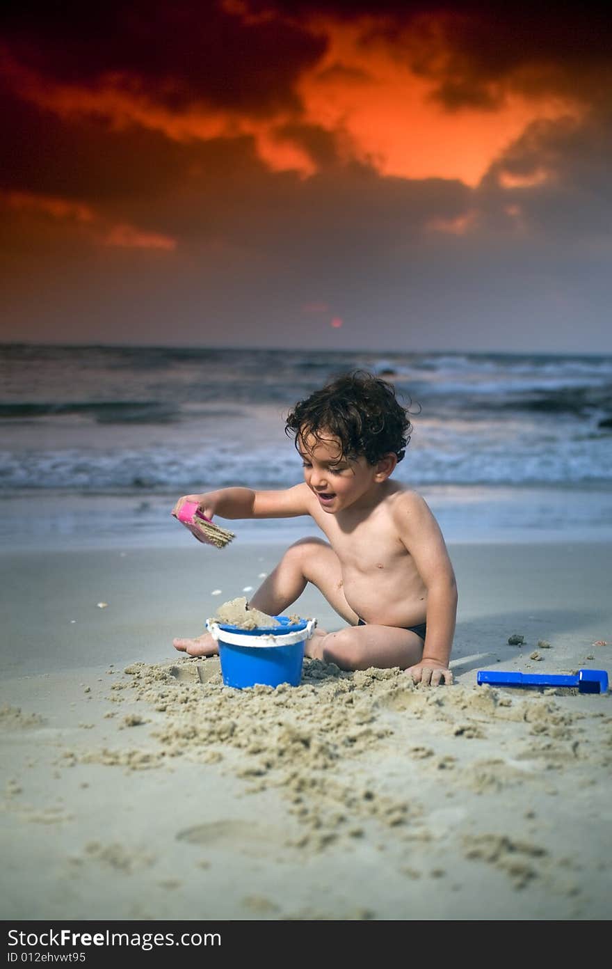 Boy play with sand on the beach at sunset. Boy play with sand on the beach at sunset