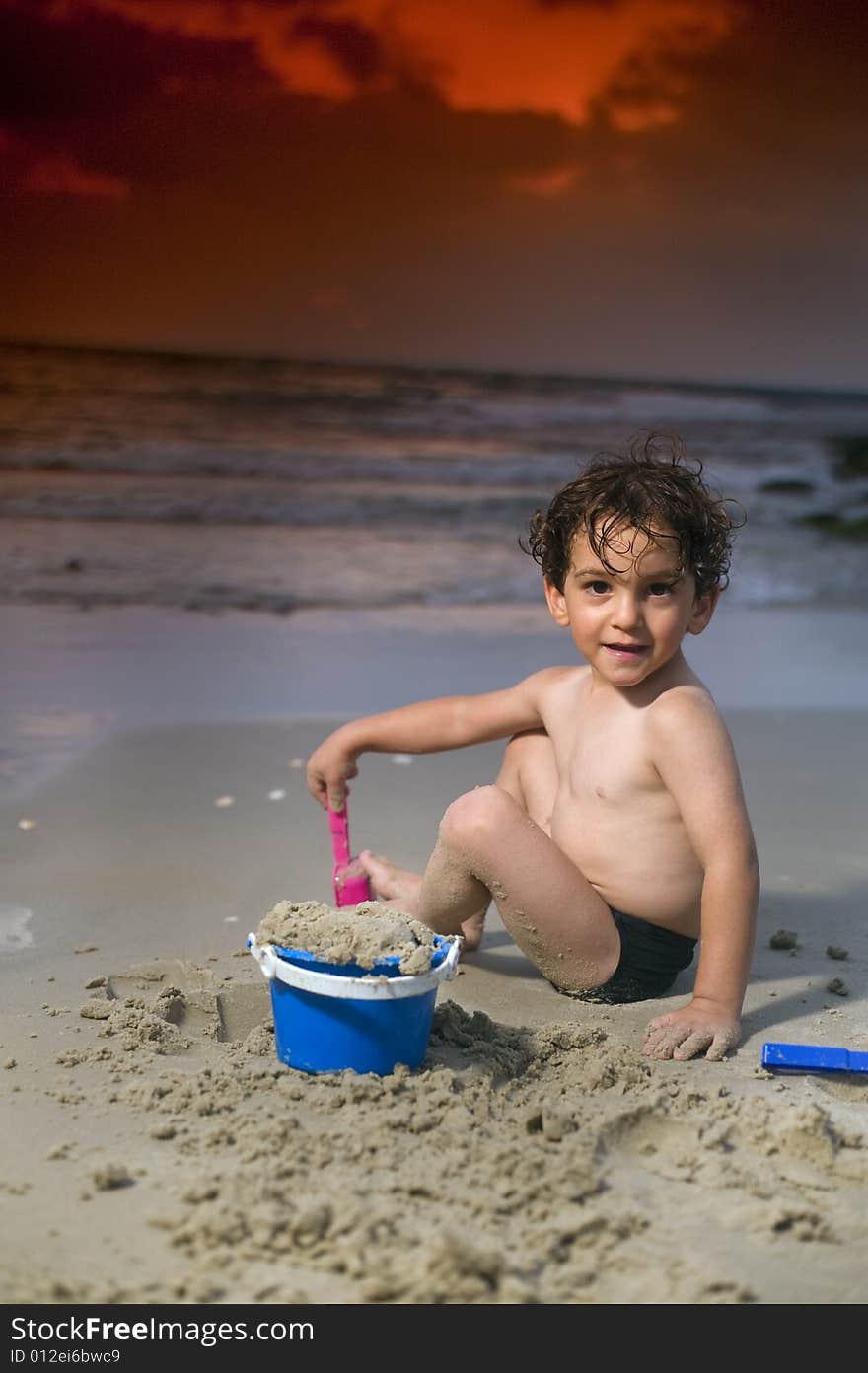 Boy play with sand on the beach at sunset. Boy play with sand on the beach at sunset