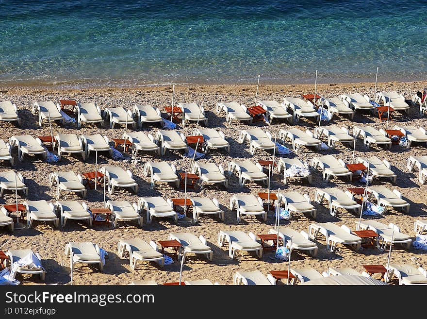 Empty chaise lounges on a morning beach