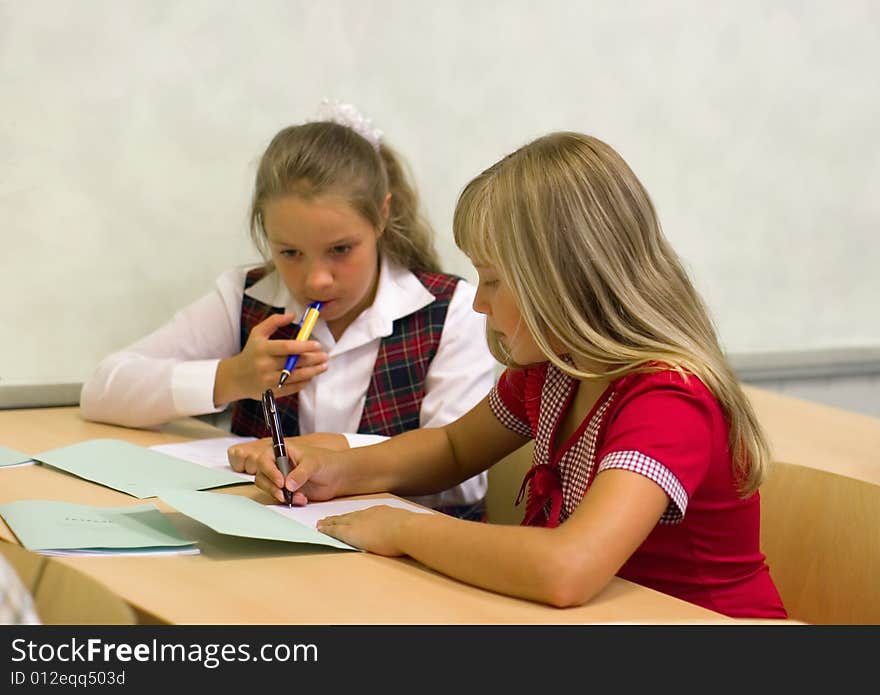 Schoolgirls talk at lesson at school. Schoolgirls talk at lesson at school.