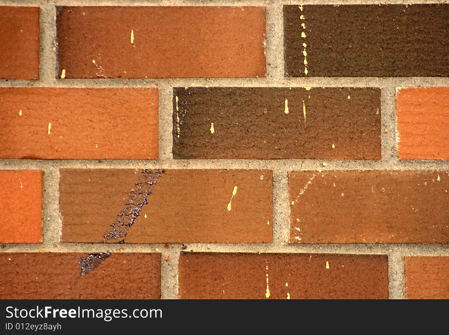 Detail of a red brick wall with some painted vandalism. Detail of a red brick wall with some painted vandalism