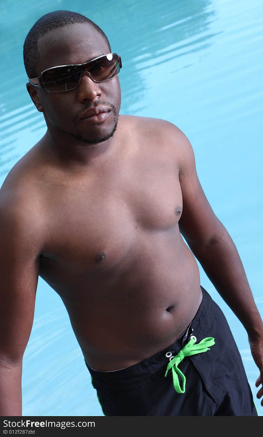 Man standing by a swimming pool. Man standing by a swimming pool