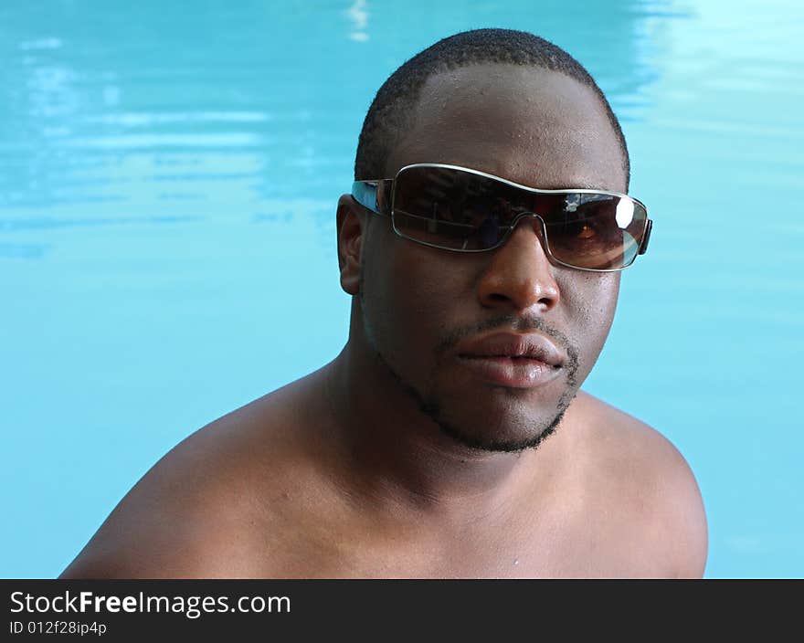 Headshot of a young man with a swimming pool in the background. Headshot of a young man with a swimming pool in the background