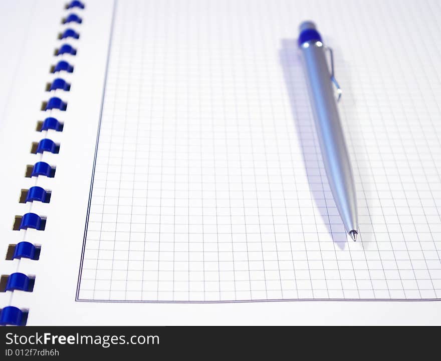 One silver pen and spiral notebook closeup. One silver pen and spiral notebook closeup