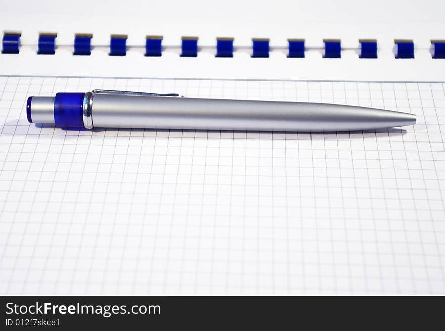 One silver pen and spiral notebook closeup. One silver pen and spiral notebook closeup