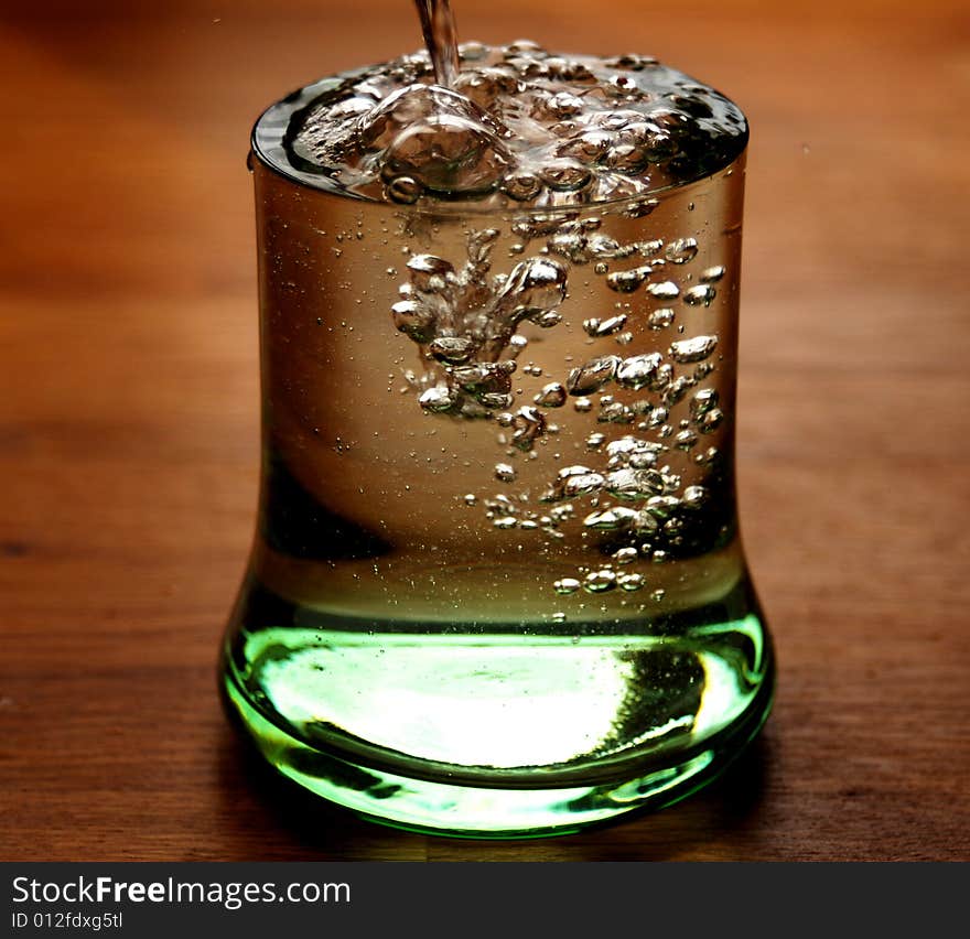 Glass of water overflowing on a table