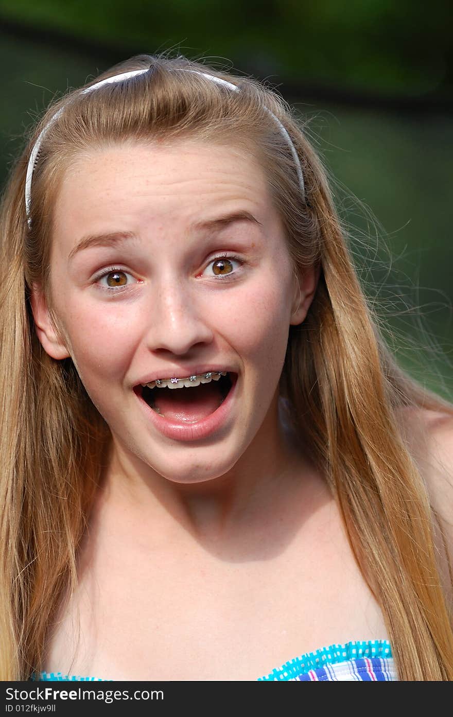 Teenager with headband and braces with surprised expression. Teenager with headband and braces with surprised expression.