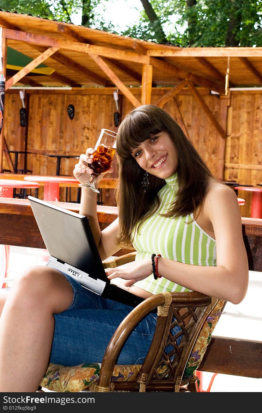 Young adul girl in bar with drink and laptop. Young adul girl in bar with drink and laptop