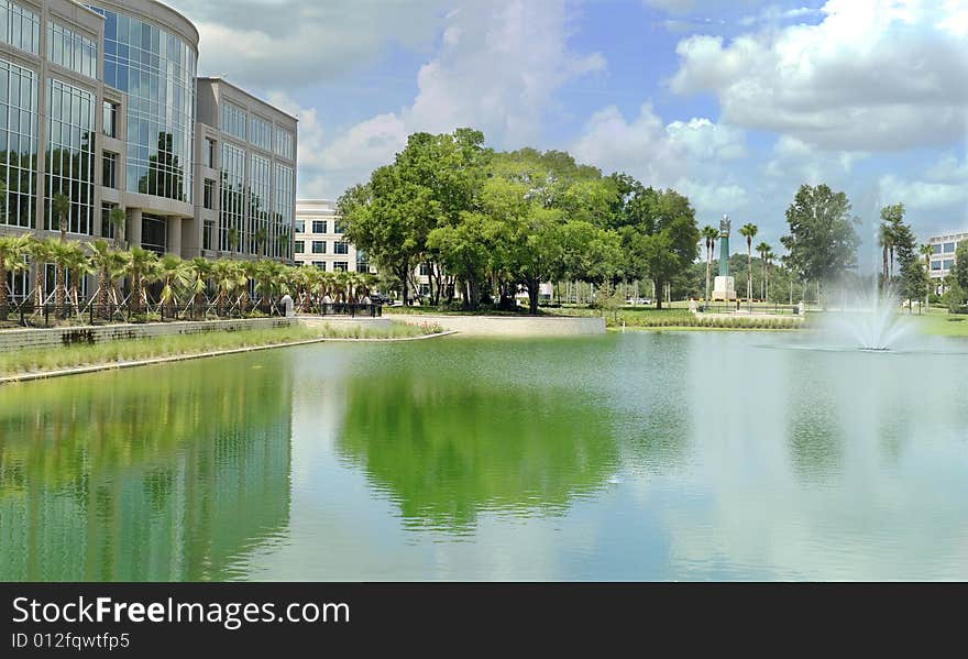 Modern office building with fountain and blue skies.