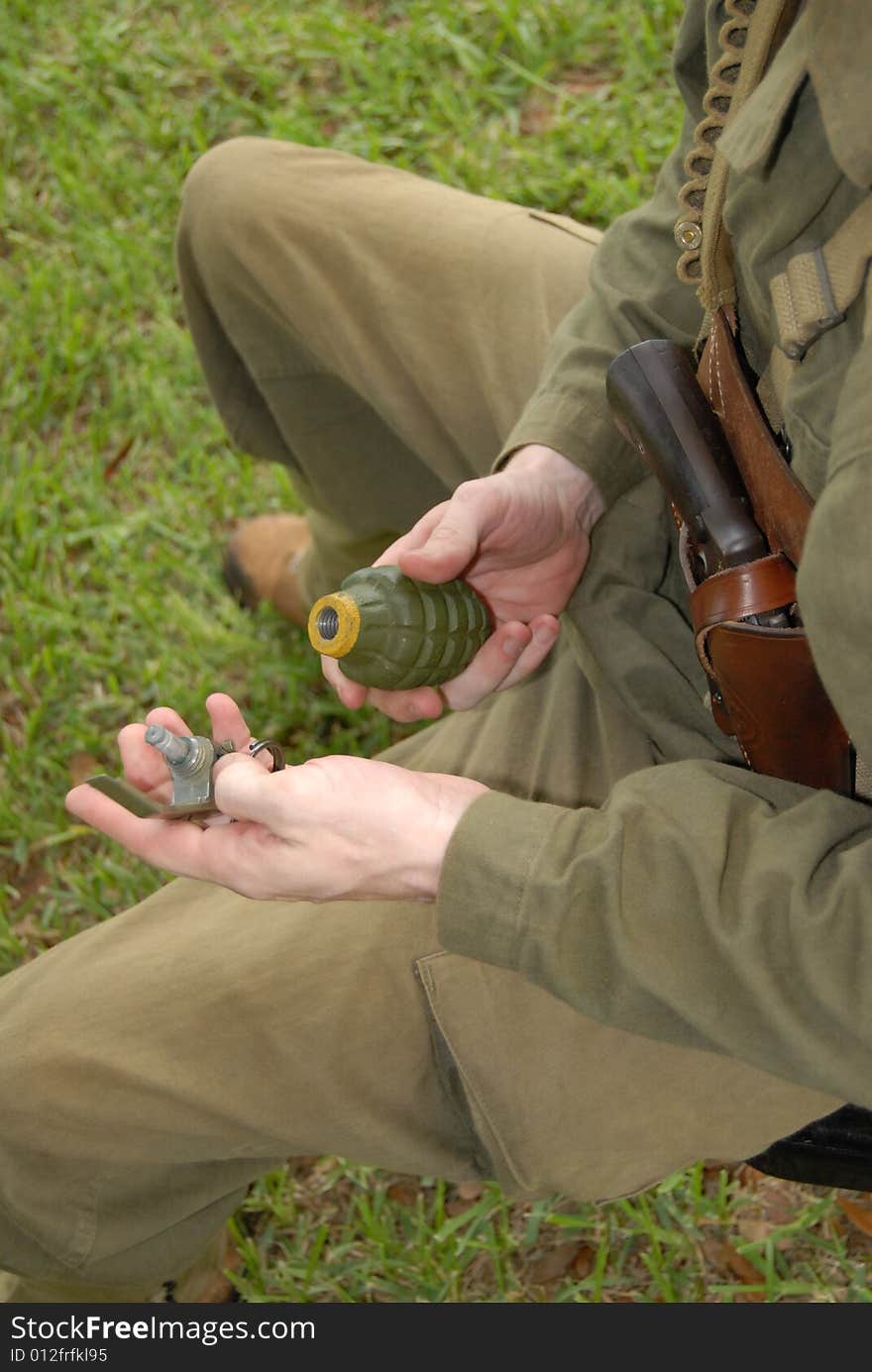 A soldier carrying a grenade. A soldier carrying a grenade