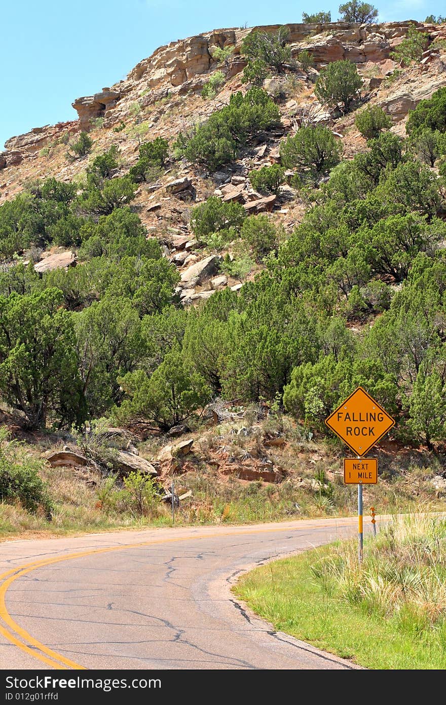 Falling Rocks sign alongside a curve in the road