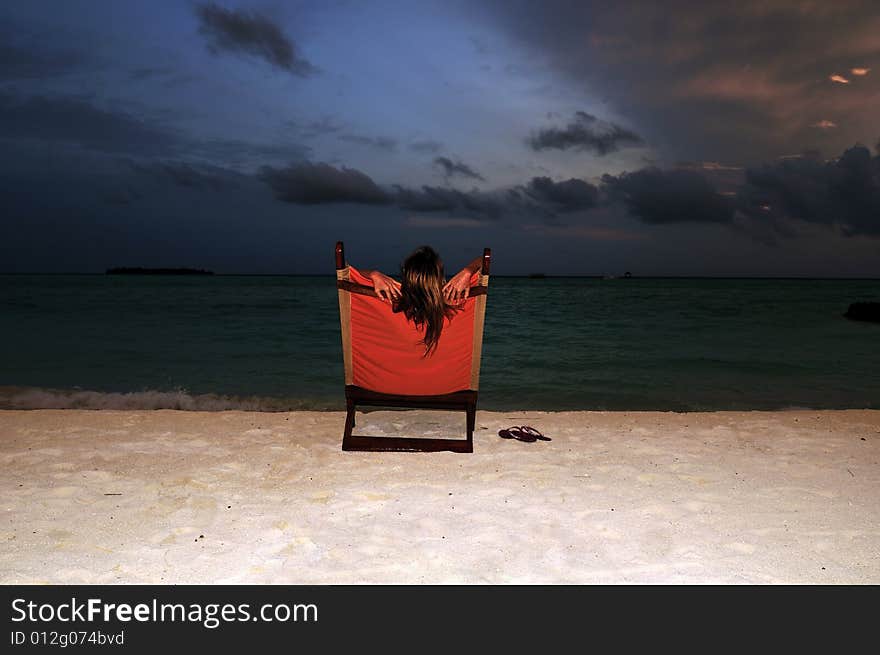 Nice vacation picture with woman sitting on a lounger. Nice vacation picture with woman sitting on a lounger