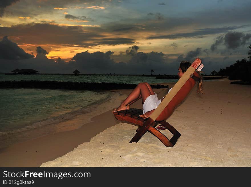 Nice vacation picture with woman sitting on a lounger. Nice vacation picture with woman sitting on a lounger