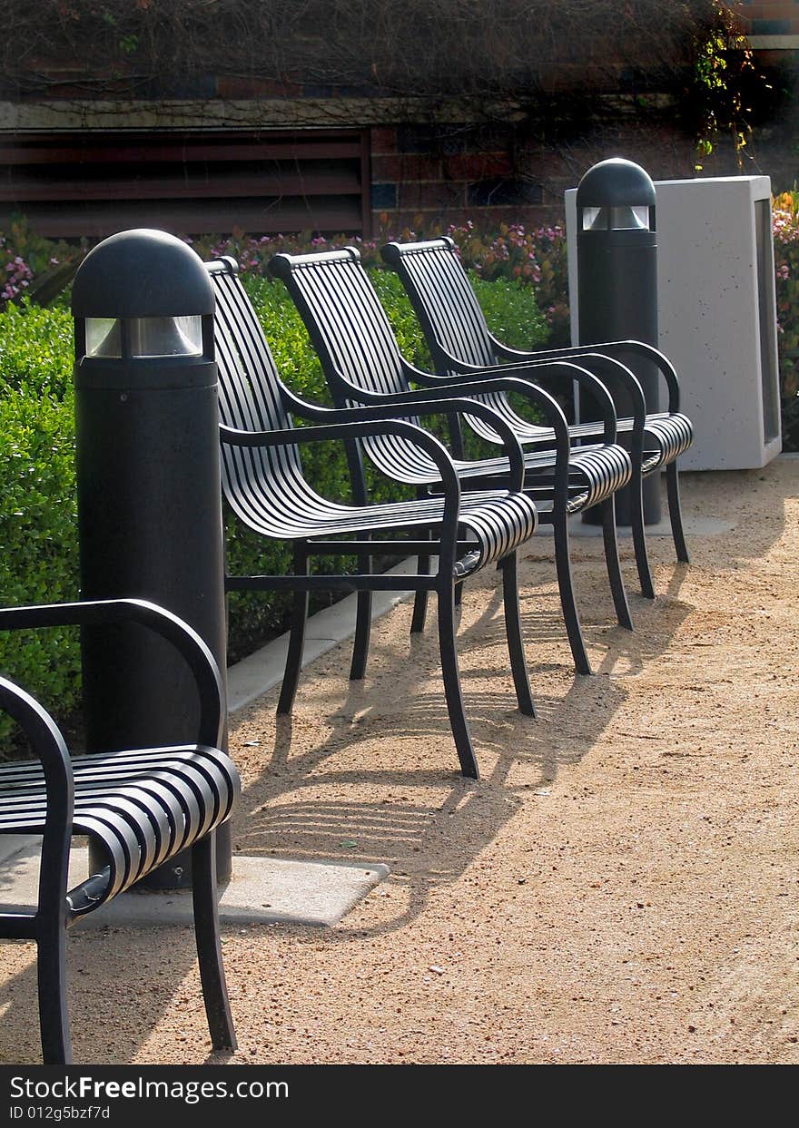 Row Of Metal Armchairs On Sand Ground