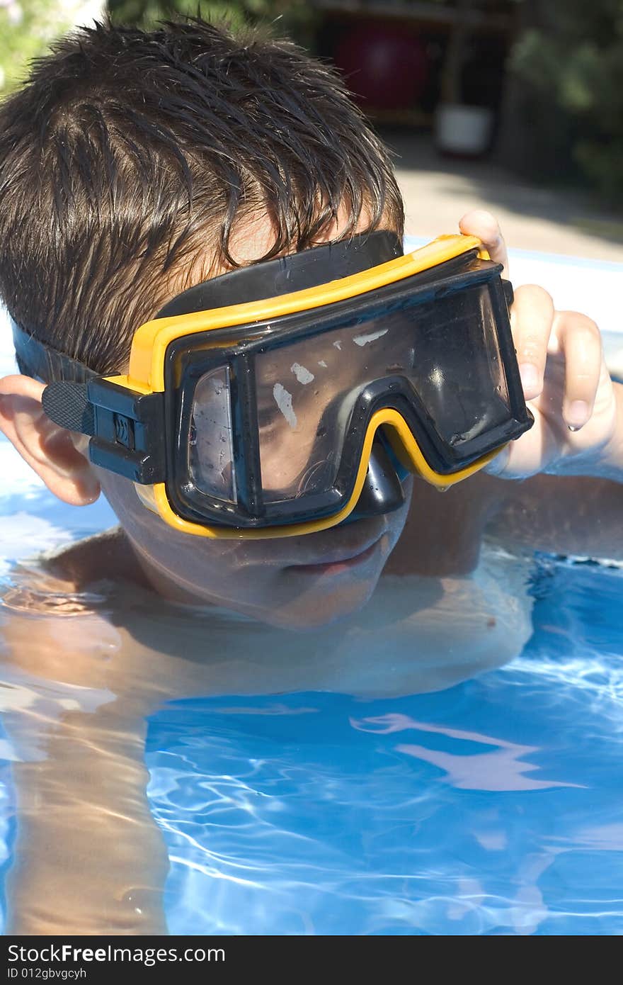 Young boy in pool with goggles on. Young boy in pool with goggles on