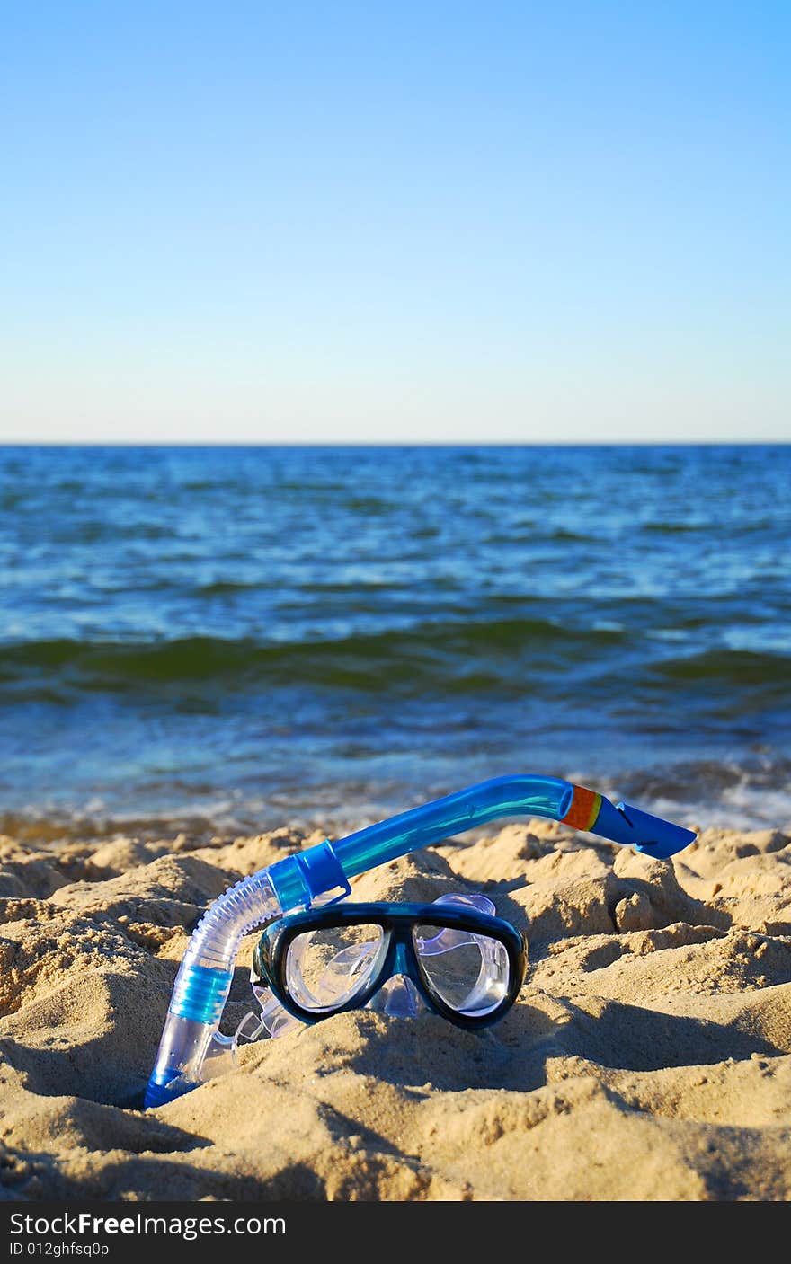 Snorkel equipment against beach and sky. Snorkel equipment against beach and sky