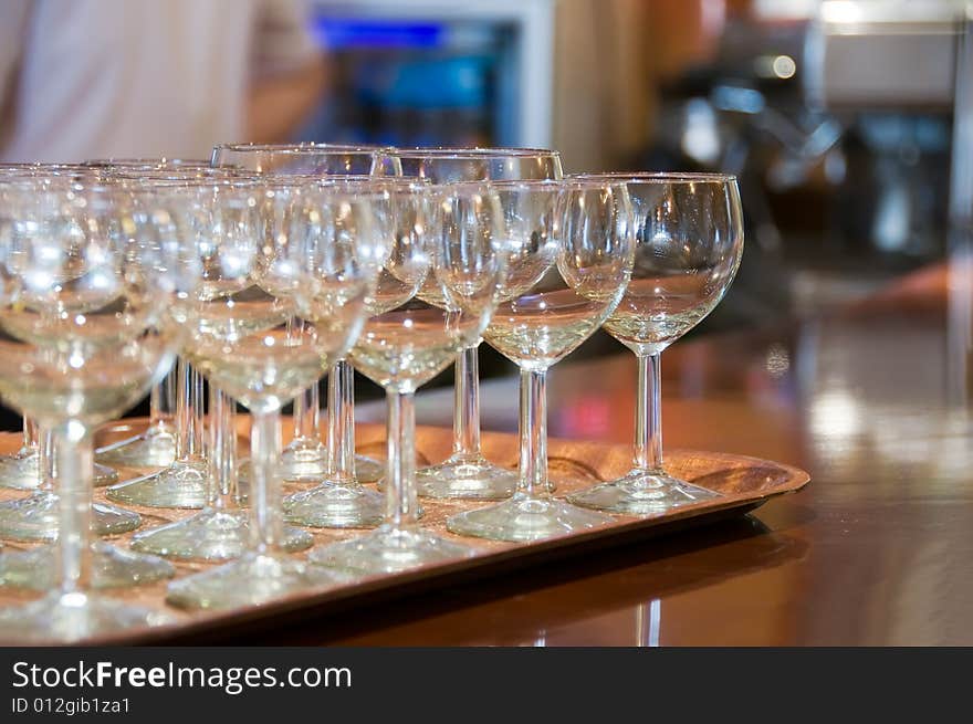 Wine glasses on tray prepared for wedding party. Tray waits on counter bar. Wine glasses on tray prepared for wedding party. Tray waits on counter bar.