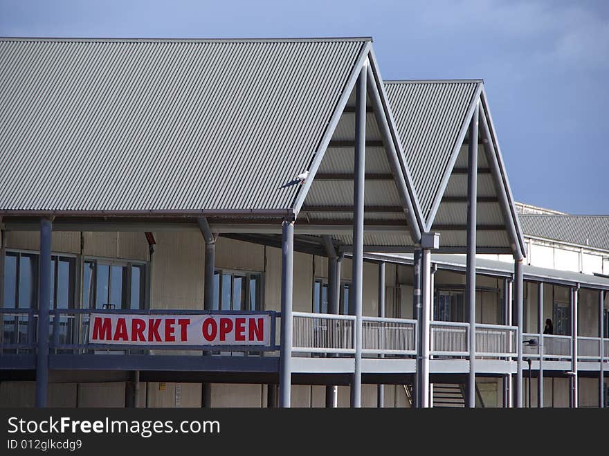 Red “Market Open” sign on the side of a large indoor market warehouse. Port Adelaide, South Australia. Possibly could be a metaphor for financal or free markets.