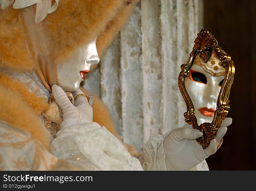 Venice carnival: a woman is playing with a mirror. Venice carnival: a woman is playing with a mirror