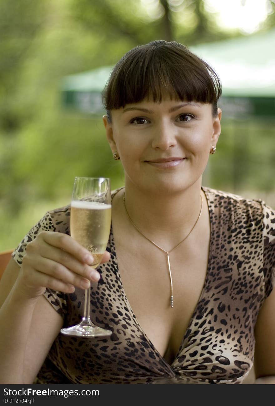 Outdoor portrait of beautiful woman  with champagne glass