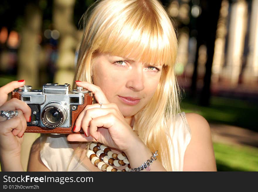 Girl in a garden holding a camera. Girl in a garden holding a camera