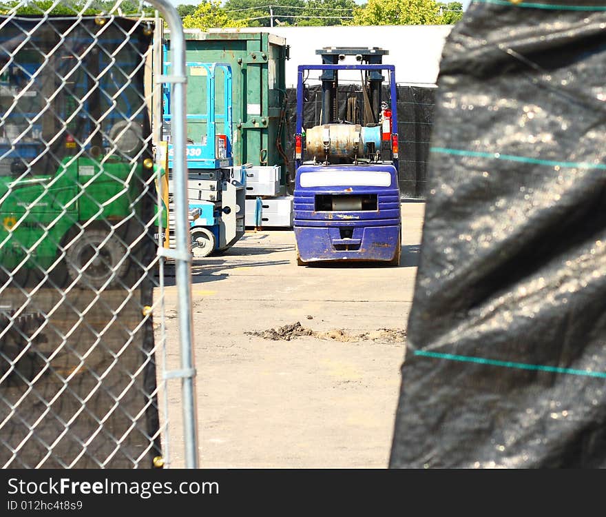 Construction vehicle behind gated fence. Construction vehicle behind gated fence