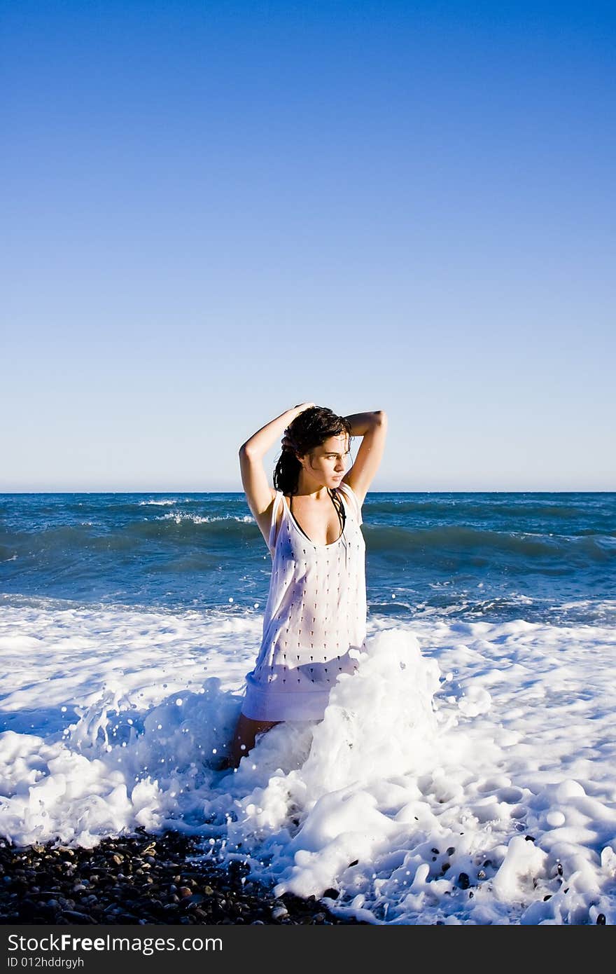 Green eyed beauty sensually posing on the beach