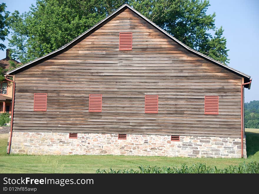 Country Barn with wood siding and stone foundation.