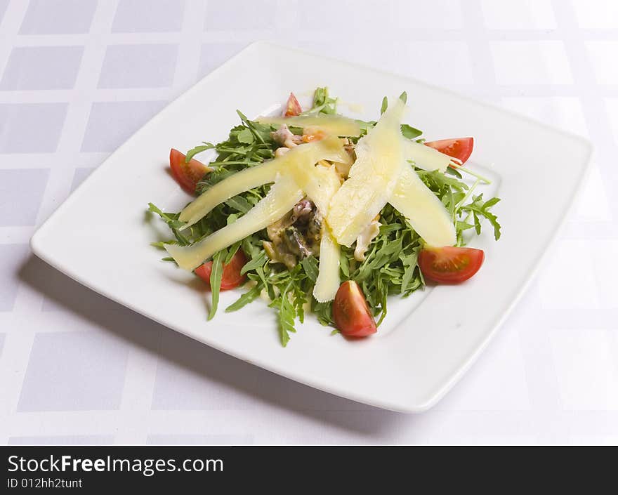 Salad with cheese and vegetables on white plate