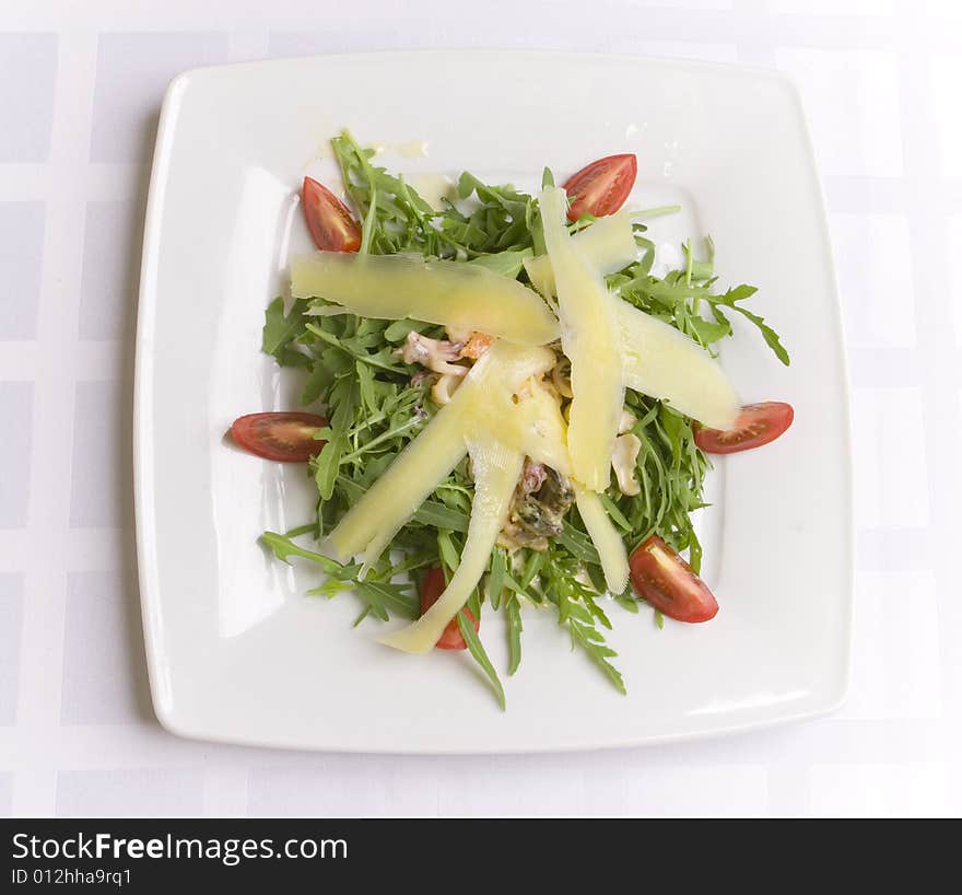 Salad with cheese and vegetables on white plate