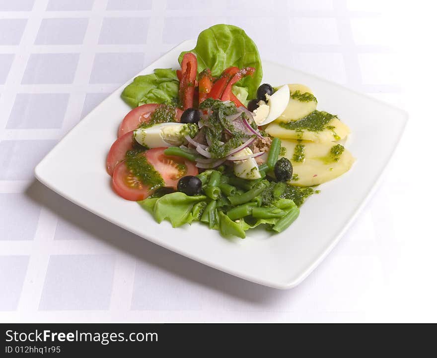 Salad with vegetables and eggs on white plate