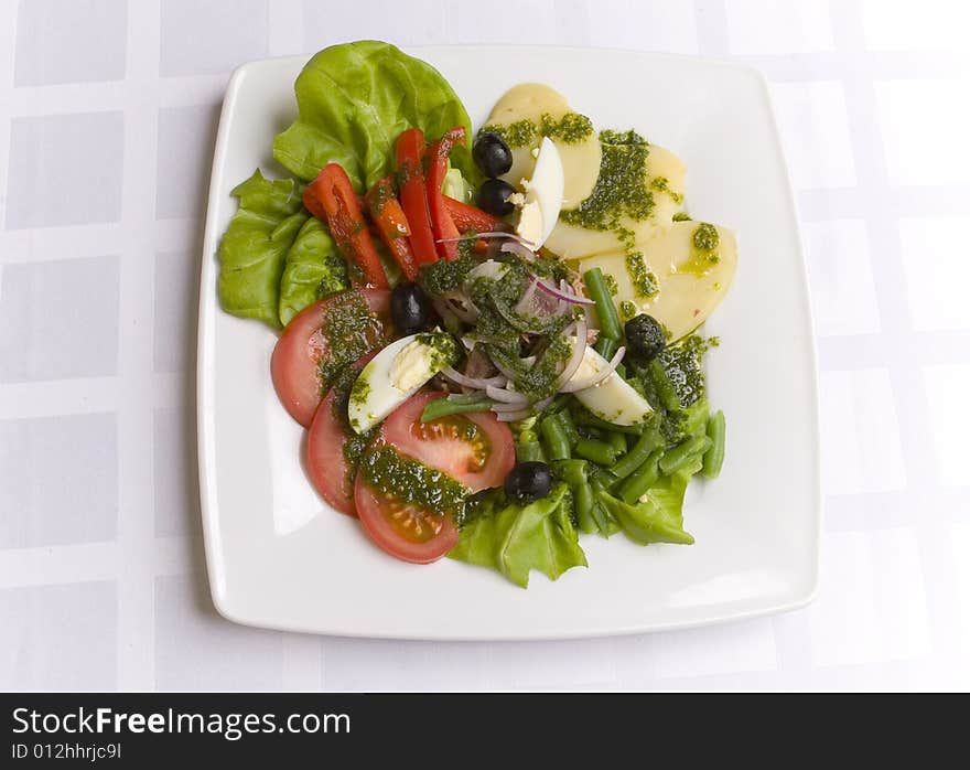 Salad with vegetables and eggs on white plate