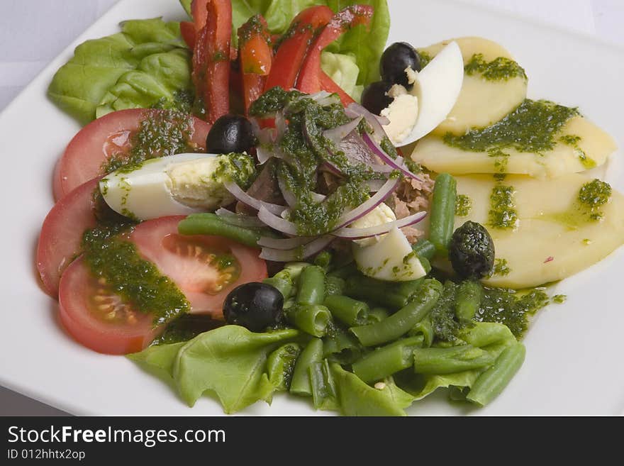 Salad with vegetables and eggs on white plate