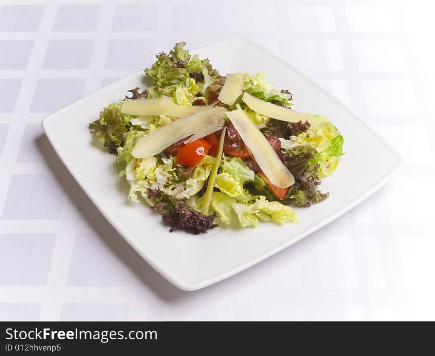 Salad with cheese and vegetables on white plate