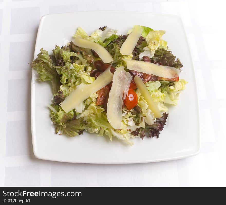 Salad with cheese and vegetables on white plate