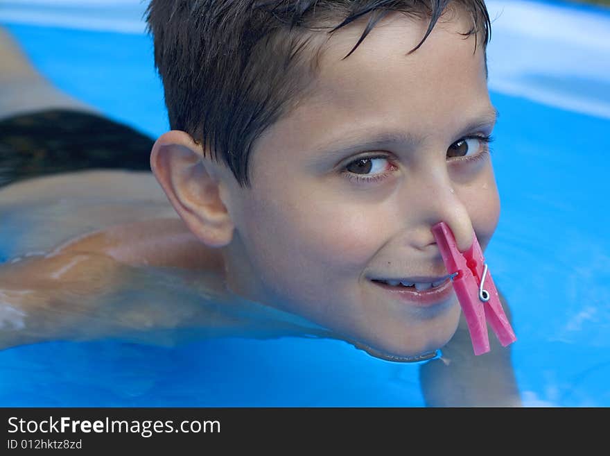 Young boy in pool  with peg