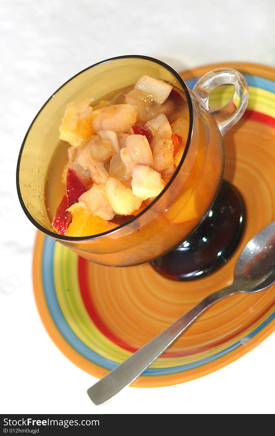 Close up of a bowl containing fresh fruit salad and a spoon