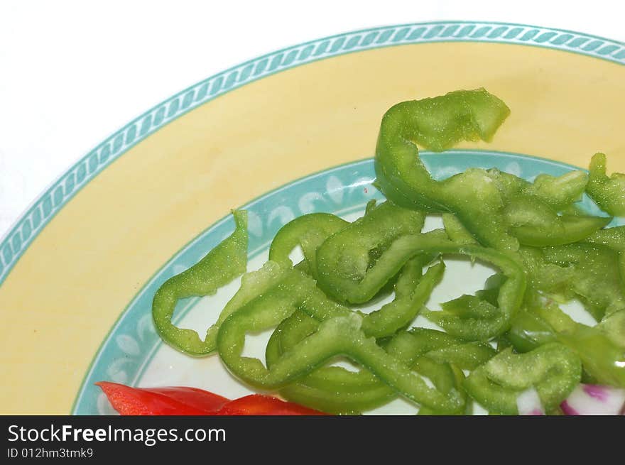 A dish with green and red pepper ready to be cooked or to be used raw. A dish with green and red pepper ready to be cooked or to be used raw