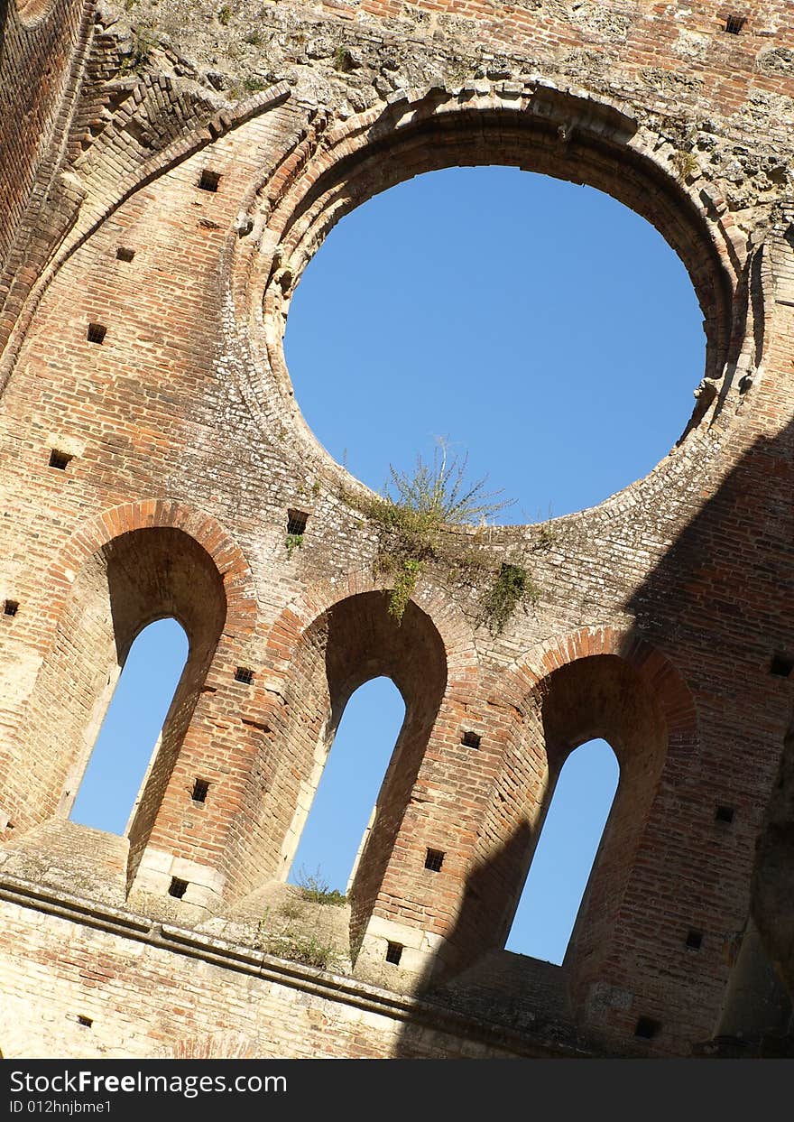 A particular shot of the ruin of the rose window and some windows of the apse in San Galgano abbey. A particular shot of the ruin of the rose window and some windows of the apse in San Galgano abbey