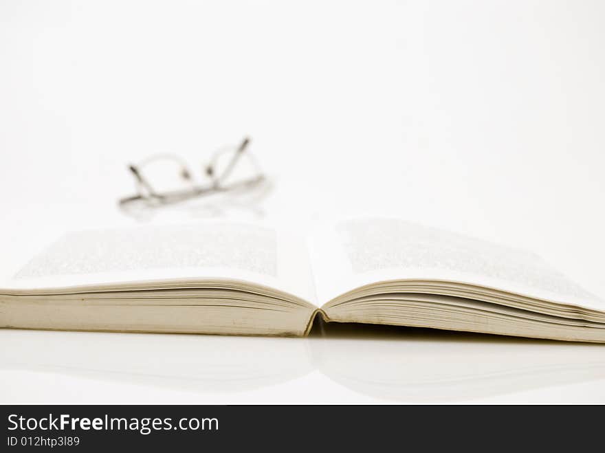 Book with eyeglasses at background