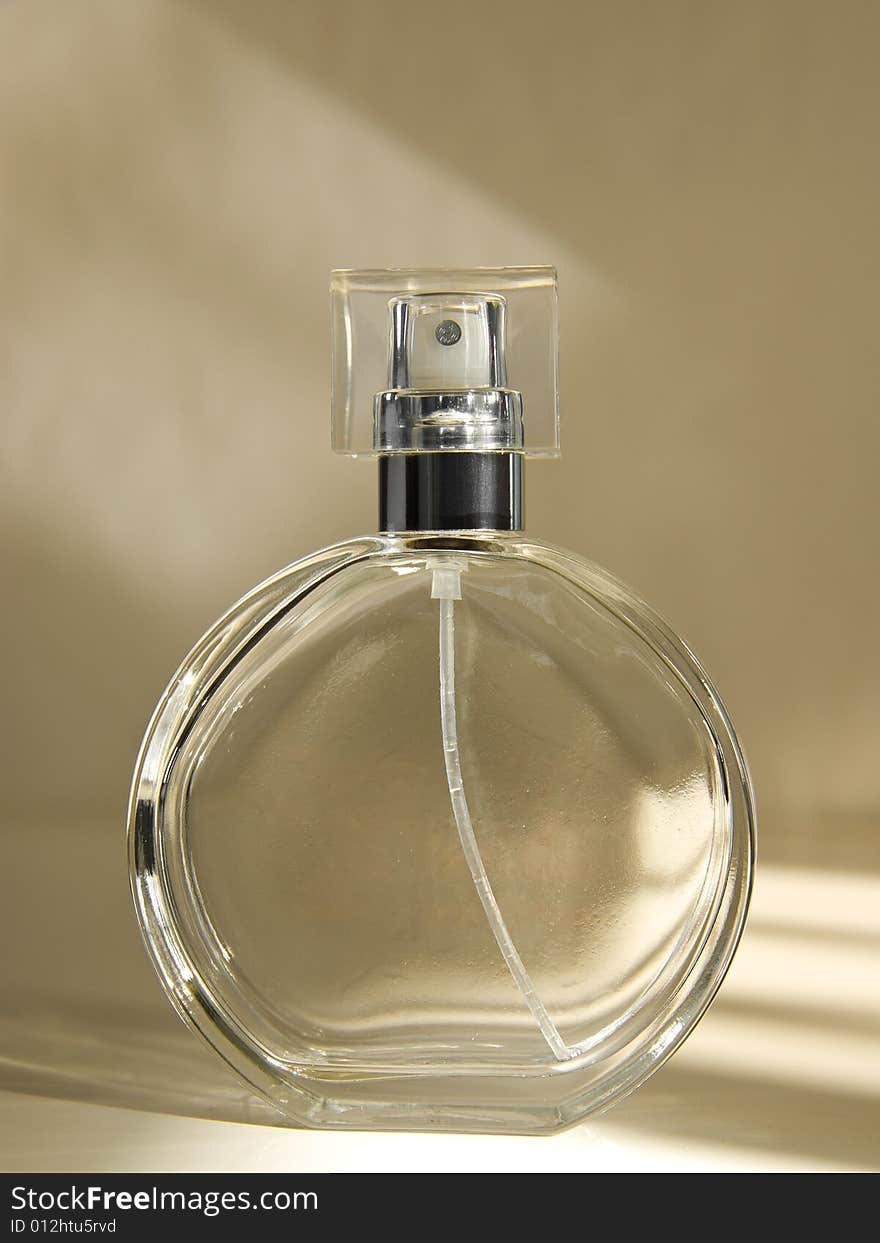 Image of an empty perfume bottle, warm dramatic lighting