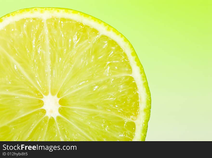 Fresh slice of lime with zesty green gradient lighting. Fresh slice of lime with zesty green gradient lighting