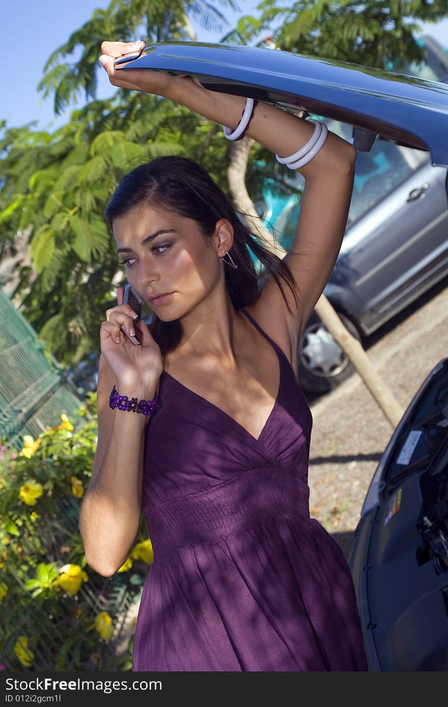 Young woman looking her broken car talking by phone. Young woman looking her broken car talking by phone