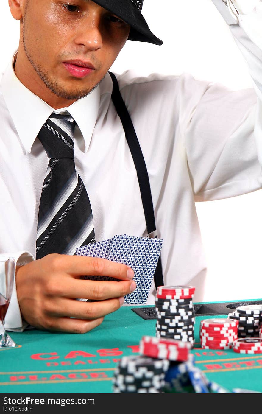 Young man playing poker with a hat and stylish suit. Isolated over white background. Young man playing poker with a hat and stylish suit. Isolated over white background.