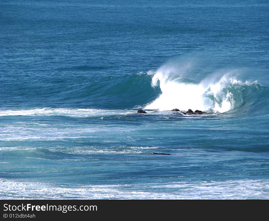 Curling wave breaking over dry rock