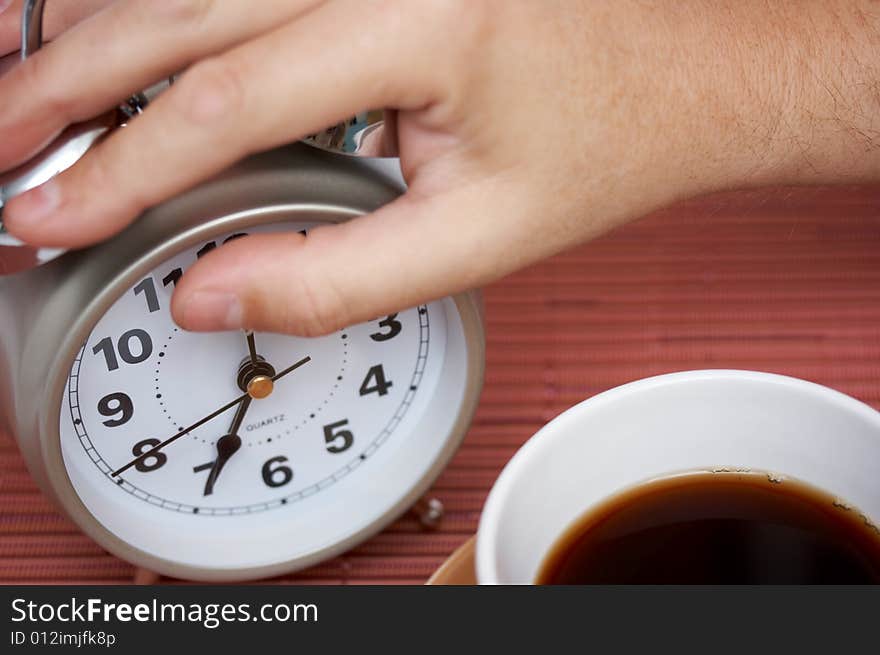 Man holding an alarm clock - turning off