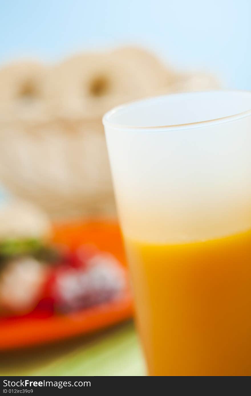 Breakfast bagels on the kitchen table over blue background with orange juice